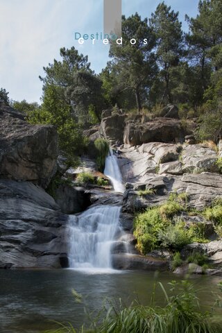 Una cascada en un entorno rocoso con vegetación en la Sierra de Gredos.